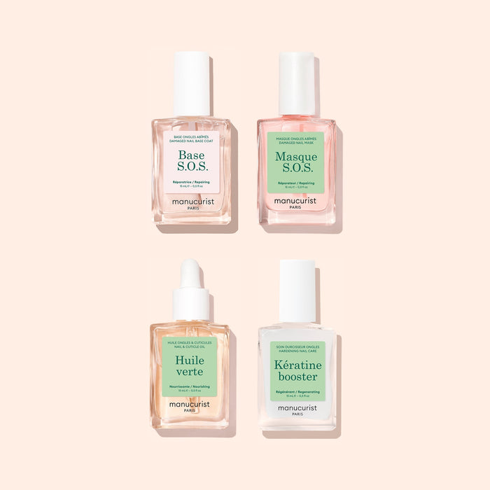 Four manicure treatment bottles from Manucuristโs Basic Routine โ Damaged Nails set arranged in a square on a light beige background, perfect for nail repair and strengthening. Labels read: Base S.O.S., Masque S.O.S., Huile verte, and Kรฉratine booster. The clear bottles feature green and pink labelsโan ideal set to help restore brittle nails.
