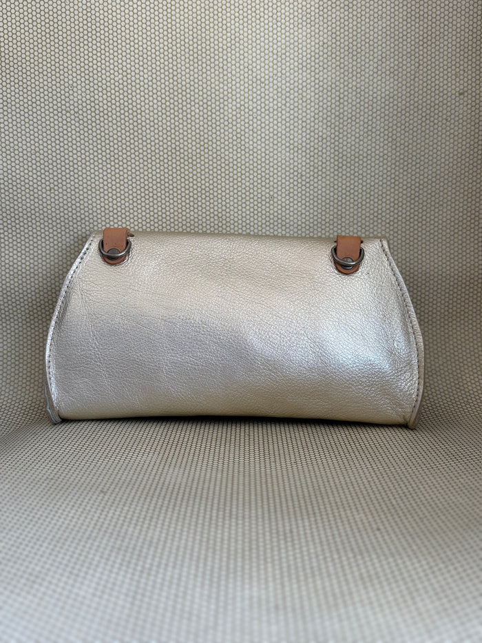silver Dean leather clutch bag on a textured surface.