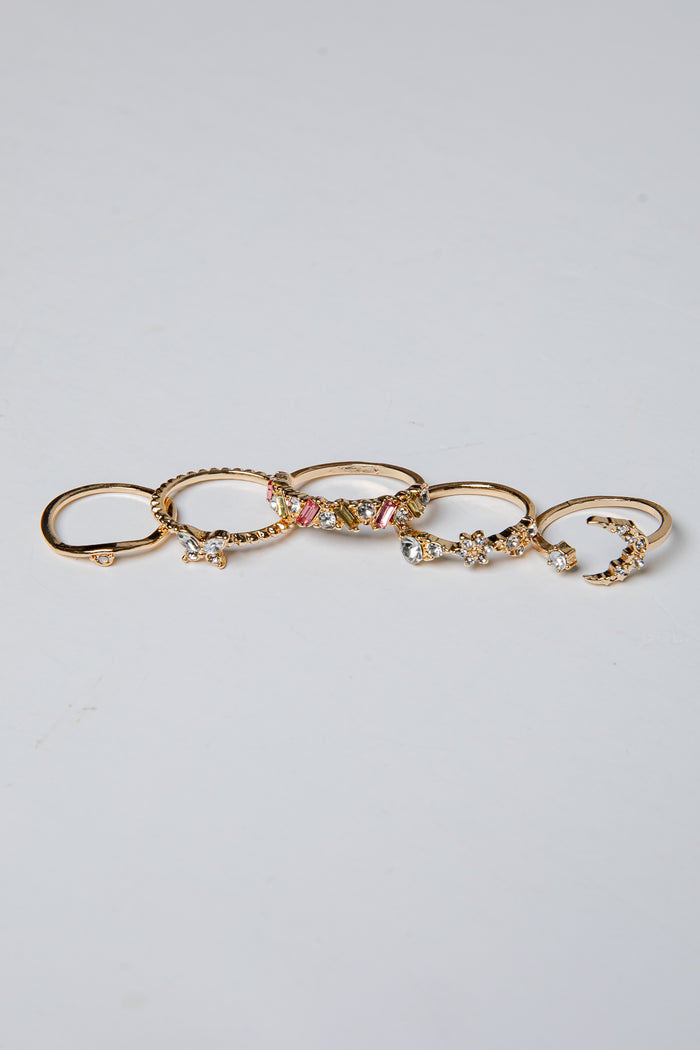 Set of gold rings with various designs on a light gray background