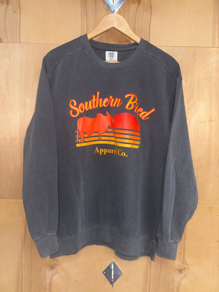 Southern Bred Apparel Company crewneck Comfort Colors brand sweatshirt in Pepper. This grey sweatshirt features a front graphic print of "Southern Bred Apparel Co." and a outline of a Brahman Bull.