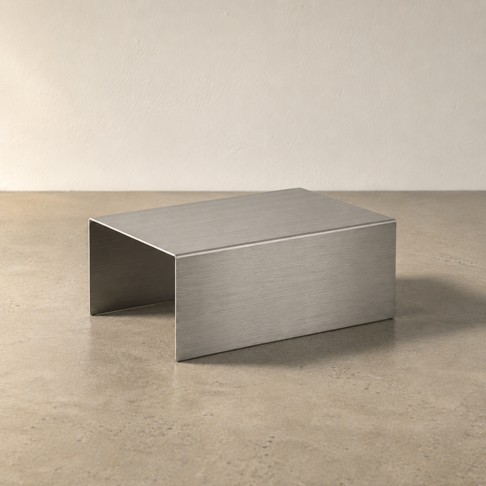 Compact rectangular stainless steel display riser shown at an angle.