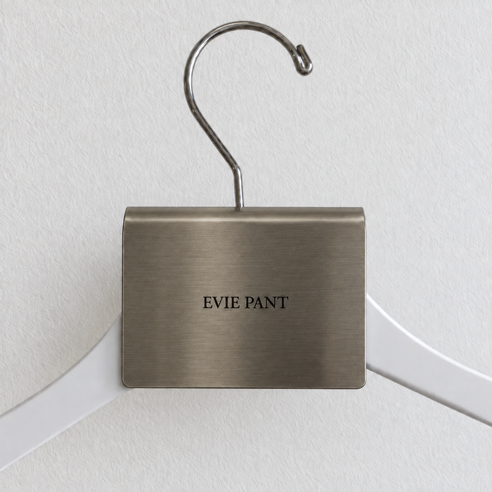 Brushed stainless steel hanger sign clip with Evie Pant lettering.