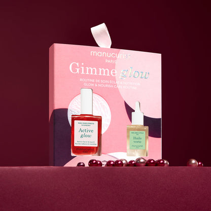 A pink box labeled 5min' Glow Manicure by Manucurist stands upright, holding two nail treatments—one red and one pale green—against a burgundy background with scattered pearls.