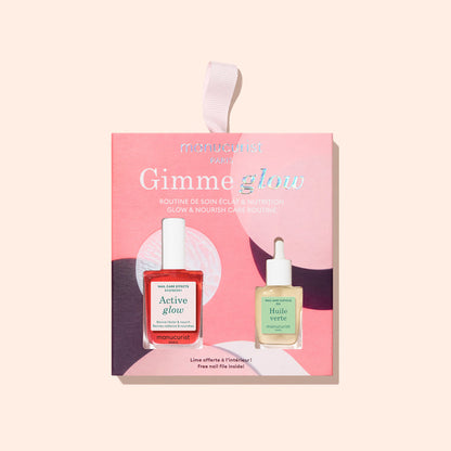 A pink, abstract-patterned box labeled "5min' Glow Manicure" by Manucurist holds two nail treatments—red Active Glow and green Huile Verte cuticle oil. Finished with a pink ribbon loop, it also doubles as a festive Christmas ornament.