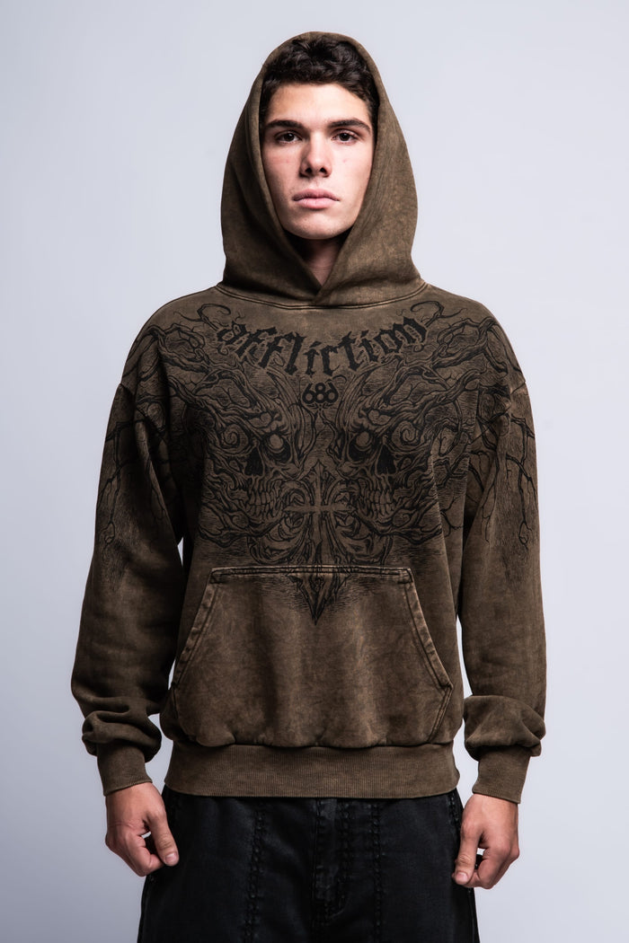 A young man faces forward against a plain light-gray background, wearing the 686 Affliction Natural Rot Pullover Hoody by 686, a brown men‚Äôs sweatshirt featuring black intricate designs and "Affliction" on the chest.