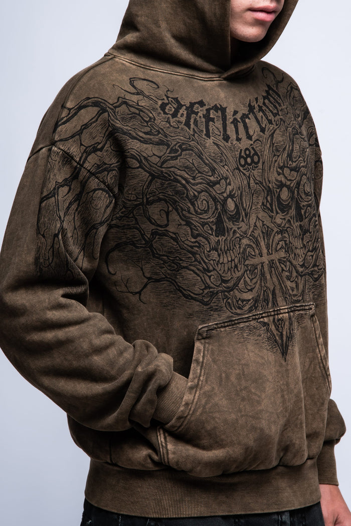 A man wears the 686 Affliction Natural Rot Pullover Hoody‚Äîa brown, cotton sweatshirt featuring a large black graphic and "Affliction" on the chest. The image shows his upper body with face partially out of frame. Brand: 686.