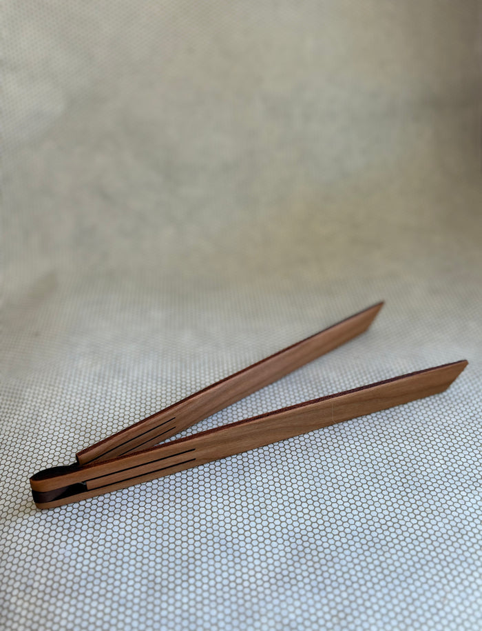 wooden inside out tongs for cooking on light neutral background. Jonathan's Spoons.