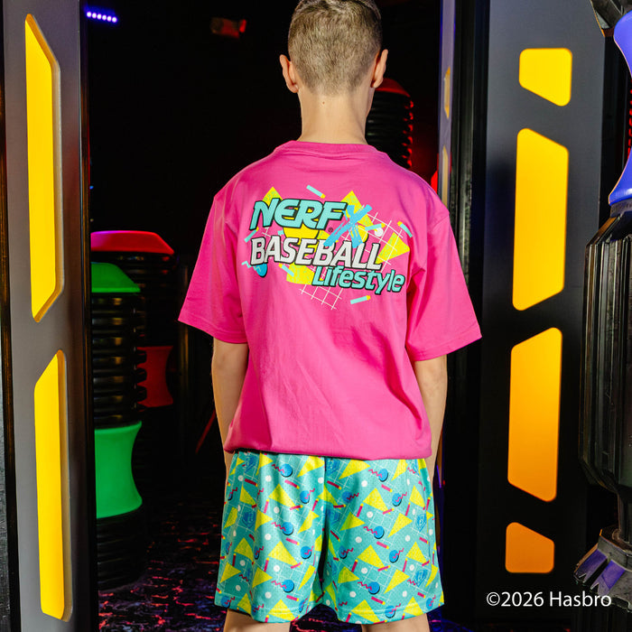 Person wearing a pink 'NERF Baseball Lifestyle' shirt and colorful shorts in front of a colorful background