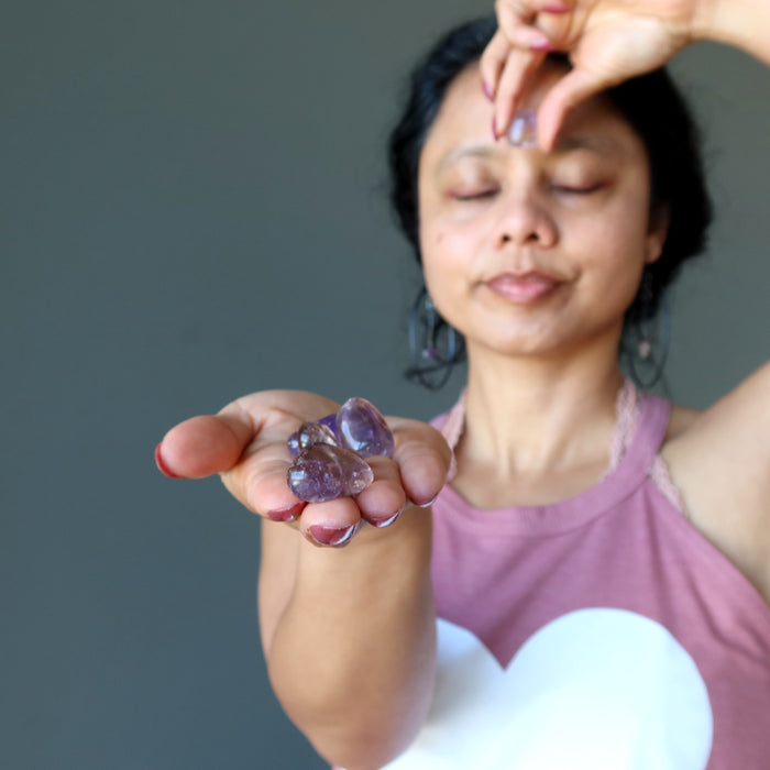 sheila of satin crysals hodling amethyst citrine tumbled stones on right hand and raising one to the third eye from left hand