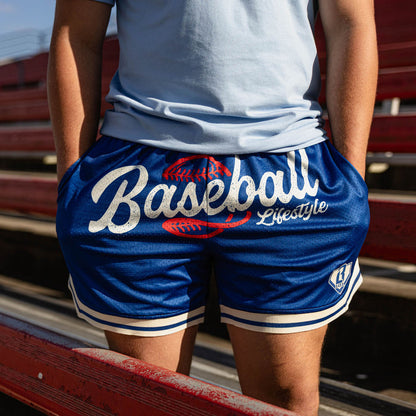 Close up of royal blue Baseball Lifestyle mesh shorts with white script graphic red baseball lace detail and white striped hem