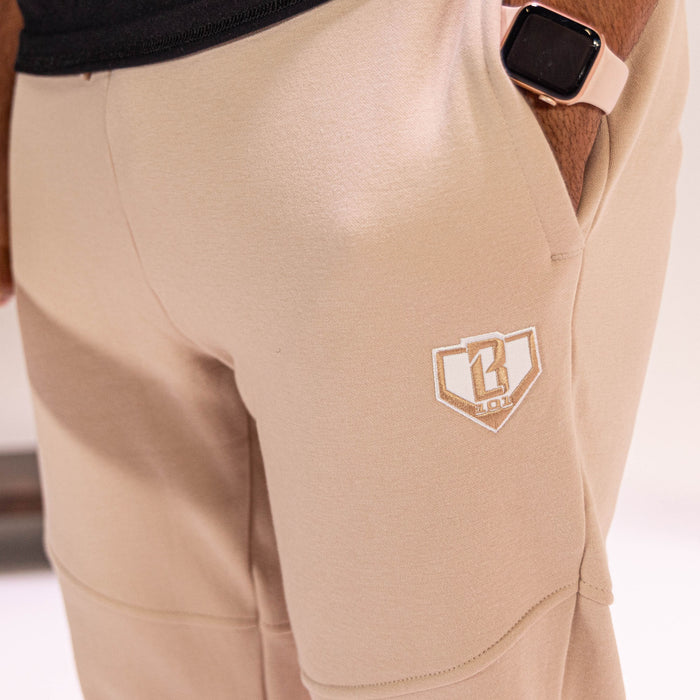 Beige sweatpants with a  BL101 logo on the pocket, worn by a person.