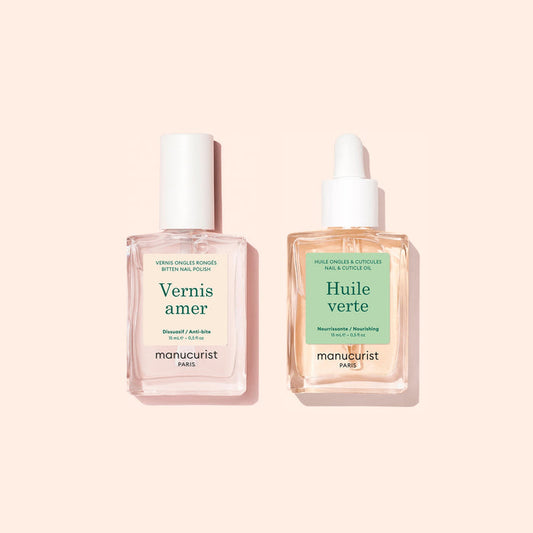 Two square bottles of Manucurist Basic Routine - Bitten Nails products—a renowned nail care duo—one with a white cap and the other with a dropper lid, set against a pale pink background.