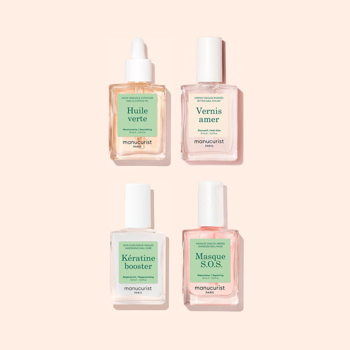 Four bottles from Manucurist’s Ultimate Routine - Bitten Nails set, each with pastel labels, are arranged in a square on a light pink background. The set features nourishing oils, a bitter polish to deter nail biting, a keratin booster for strengthening nails, and an SOS mask to promote healthy nail regrowth.