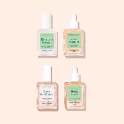 Four manicure treatment bottles from Manucurist’s Basic Routine - Soft Nails set, each featuring white caps and green labels—“Kératine booster,” “Sérum complet,” “Base fortifiante,” and “Huile verte”—are arranged in a square on a light pink background. Ideal for anyone looking to strengthen soft nails or enhance their nail care routine.