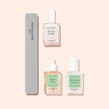 The Manucurist Starter Routine - Yellow Nails, featuring three nail care essentials for brightening and strengthening—Active Bright, Huile Verte, and Kératine Booster—alongside a grey nail file, all arranged neatly on a pale peach background.