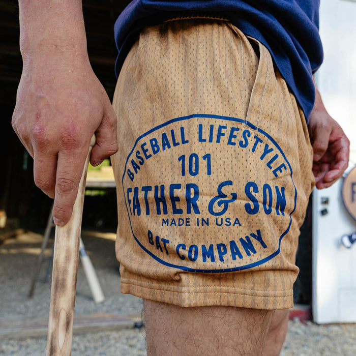 Side detail shot of the brown BL101 Bat Co Shorts highlighting the large Father & Son Bat Company oval stamp graphic on the left leg.