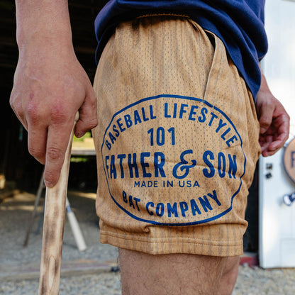 Side detail shot of the brown BL101 Bat Co Shorts highlighting the large Father & Son Bat Company oval stamp graphic on the left leg.