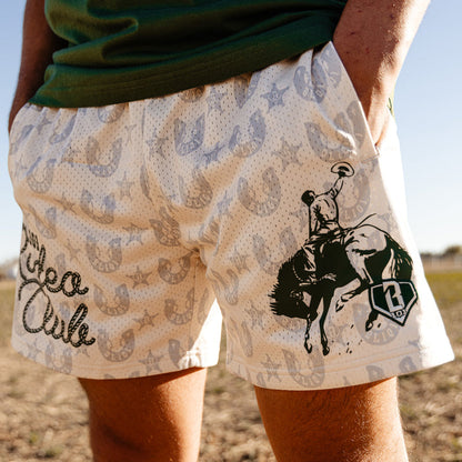 Beige shorts with horse and rider and horshoe design and BL101 Rodeo Club text on a person outdoors.