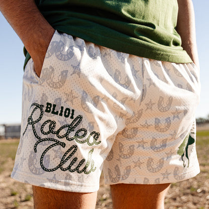 Person wearing shorts with 'BL101 Rodeo Club' text and pattern, standing outdoors.