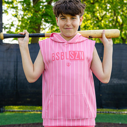 Youth player holding a bat over his shoulders wearing the pink pinstripe Jackson Olson x BL101 BSBL-SZN Short Sleeve Hoodie V3