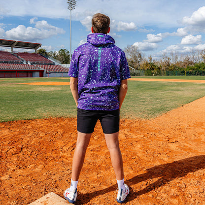 Youth model wearing splatter purple and teal BSBL-SZN youth short sleeve hoodie