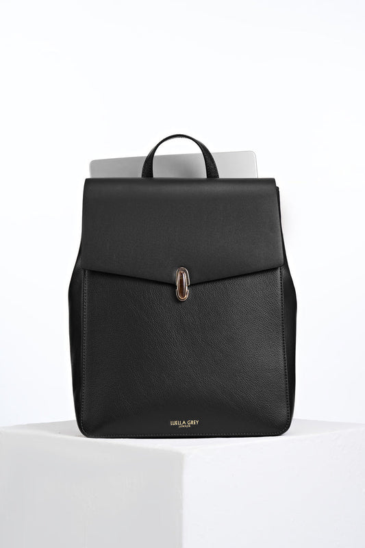 Front view of Casey Black faux leather Laptop Backpack showing resin Waterloo Twist Lock closure on the front flap and a laptop in the back pocket