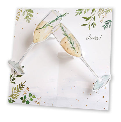 Open pop-up champagne toast card with gold leaf accents and “cheers!” script