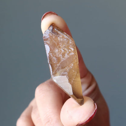 hand holding raw yellow citrine point