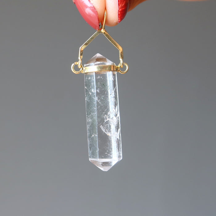 hand holding clear quartz double terminated pendant