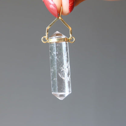 hand holding clear quartz double terminated pendant