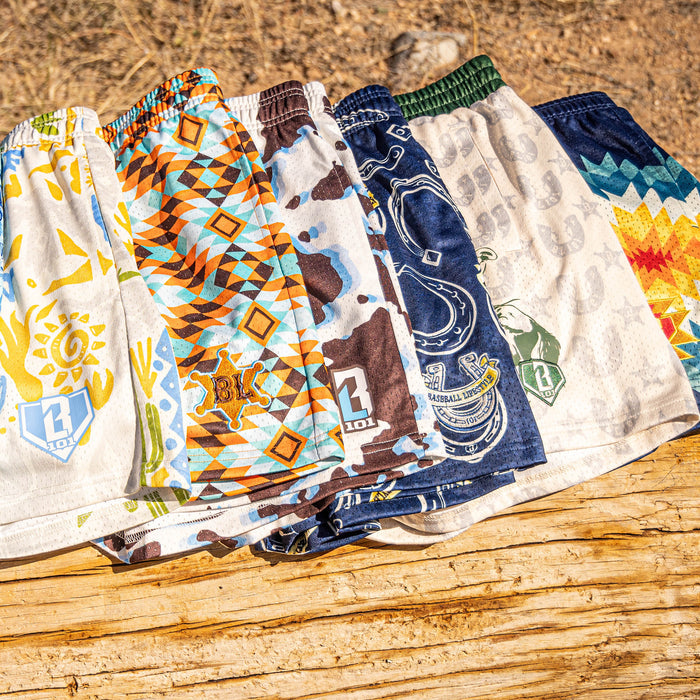 Six desert and cowboy patterned shorts on a wooden surface