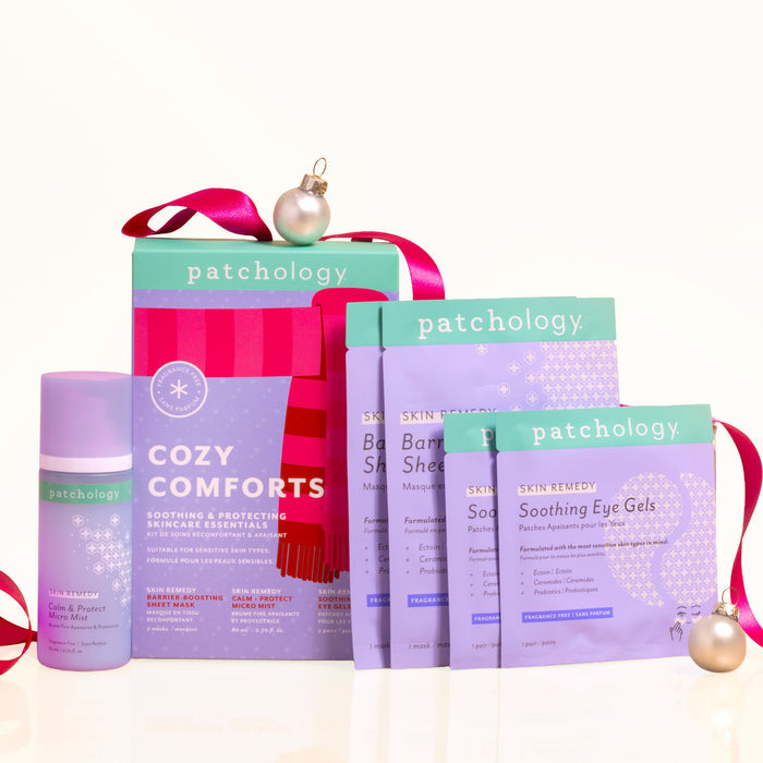 Cozy Comforts soothing skincare kit box with its calming micro mist, barrier-boosting sheet masks, and soothing eye gels, plus pink ribbon and ornaments