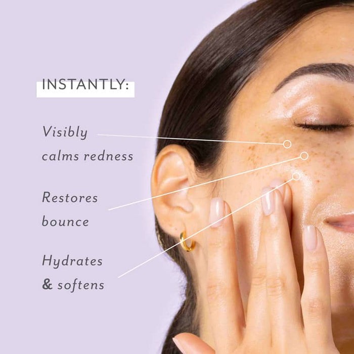 Freckled woman with dewy skin touching her cheek, eyes closed, against a lavender backdrop with text listing instant benefits: calms redness, restores bounce, hydrates and softens.