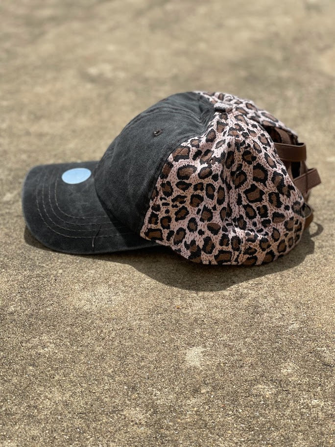Distressed black cap with a brown leopard print back.  The back has elastic crisscrossing bands and a adjustable Velcro back for a truly adjustable fit for your ponytails or buns. Side View