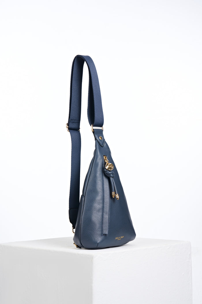 Side view of Darla Denim Blue faux leather Sling Crossbody with the adjustable crossbody strap