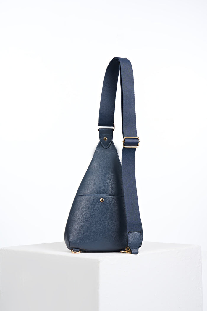 Back view of Darla Denim Blue faux leather Sling Crossbody showing the back slip in pocket with gold mag dot closure