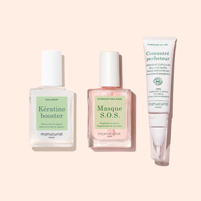 Three manicure products for nail care on a light pink background: a square bottle of Manucurist Nail Strengthening Serum, a square bottle of Masque S.O.S. overnight nail mask, and a tube of Concentré perfecteur.