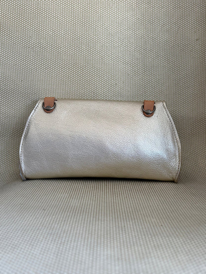 silver Dean leather clutch bag on a textured surface.
