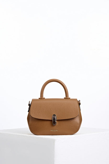 Front of Delia Tan faux leather Top Handle Crossbody without detatchable crossbody strap showing resin Waterloo twist lock clasp closure detail