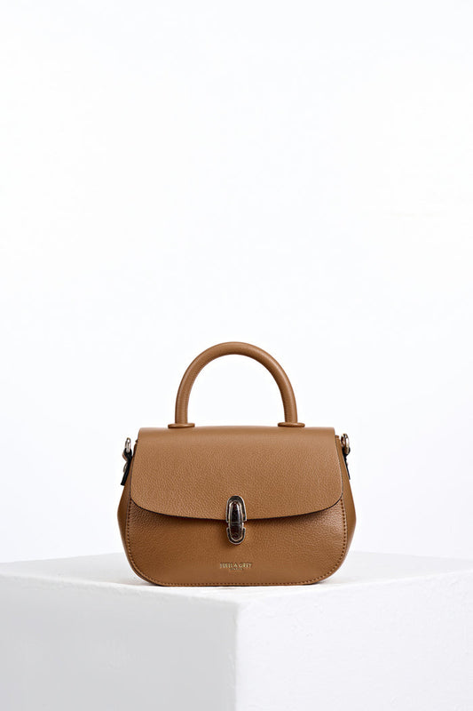 Front of Delia Tan faux leather Top Handle Crossbody without detatchable crossbody strap showing resin Waterloo twist lock clasp closure detail