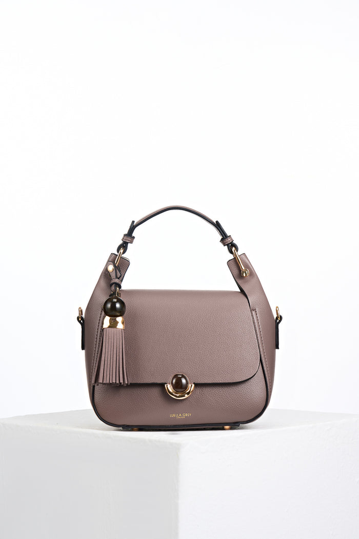 Front view of Diana Fawn faux leather Top Handle Crossbody with gold and resin Thames Tassel and Signature Crystal Palace Clasp closure detail