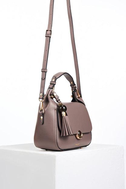 Side view of the Diana Fawn faux leather Top Handle Crossbody with the detachable crossbody strap attached to the gold rings on the side of the bad