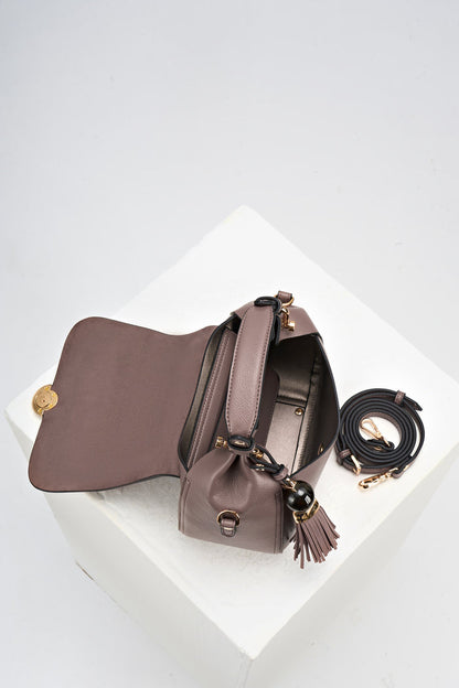 Overhead view of Diana Fawn faux leather Top Handle Crossbody with the top flap open and a view of the inside of the bag with the detachable crossbody strap rolled up next to the bag