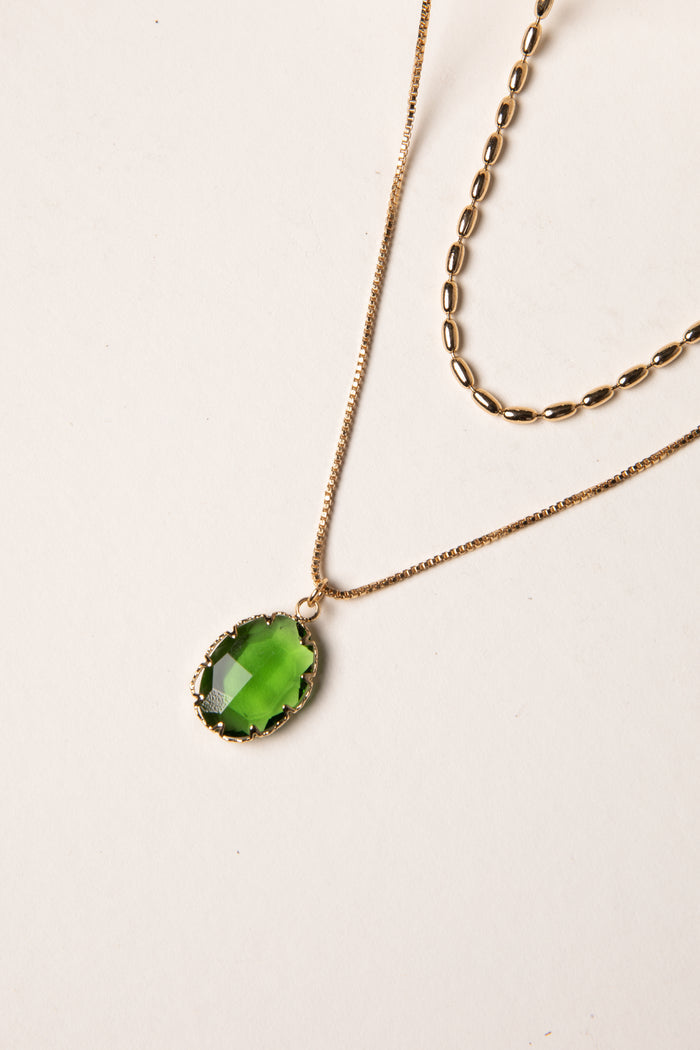 Necklace with a green pendant on a light background