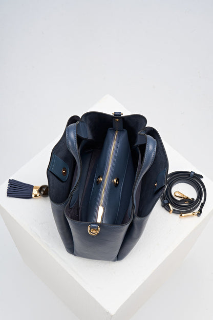 Overhead view of Etta Denim Blue faux leather Small Tote showing the inside and removable interior pouch with detachable crossbody strap rolled up next to the bag