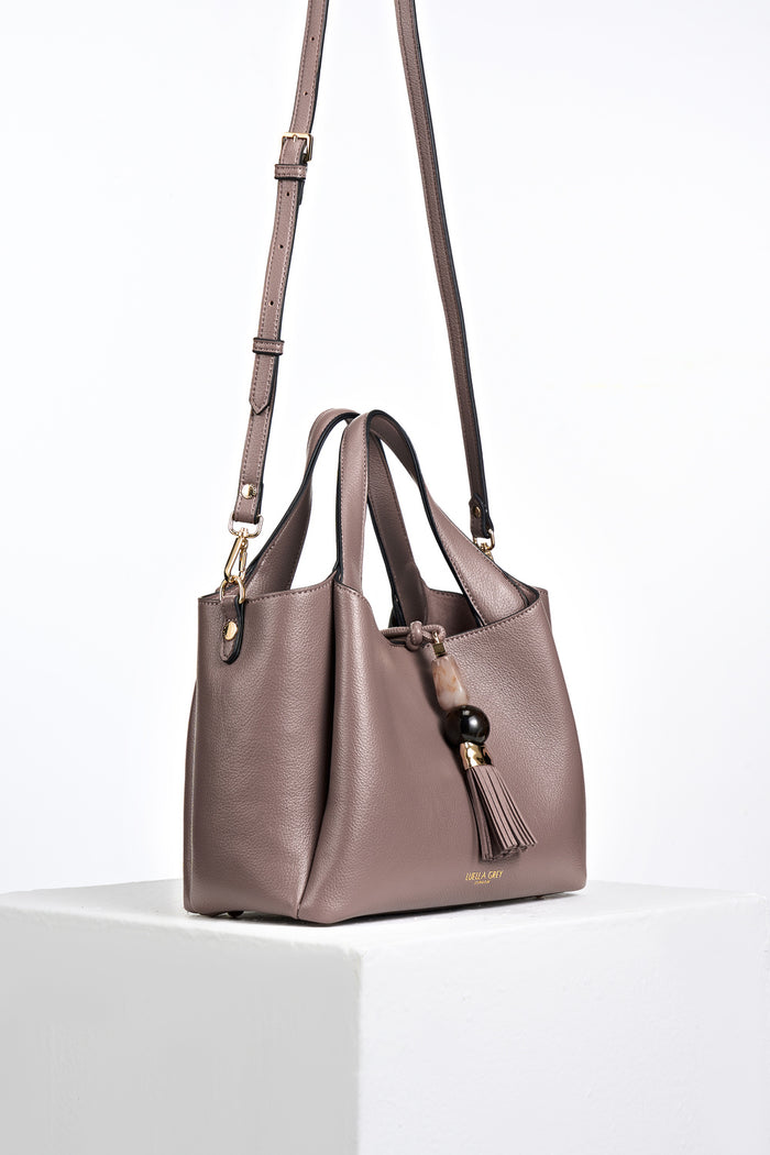 Side view of Etta Fawn faux leather Small Tote with detachable crossbody strap attached to the gold rings on the bag's side