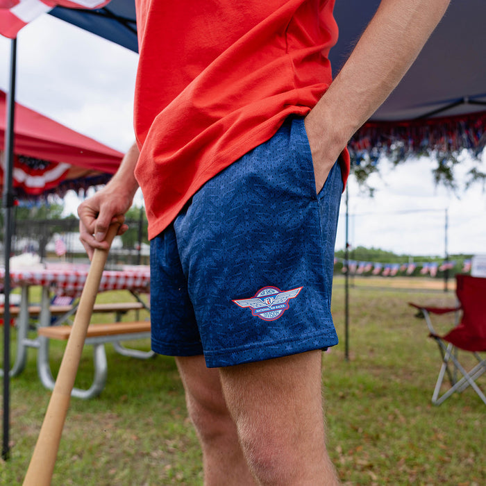 Adult model wearing navy shorts with “Fastball Flight” design