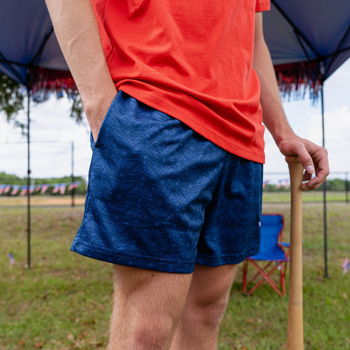 Adult model wearing navy shorts with “Fastball Flight” design