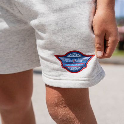 Detail close-up of Air Show National Air Races Division embroidered badge on heather gray youth sweatshorts leg