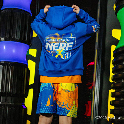 Child wearing a blue hoodie with 'NERF X BL101' branding in front of toy guns.